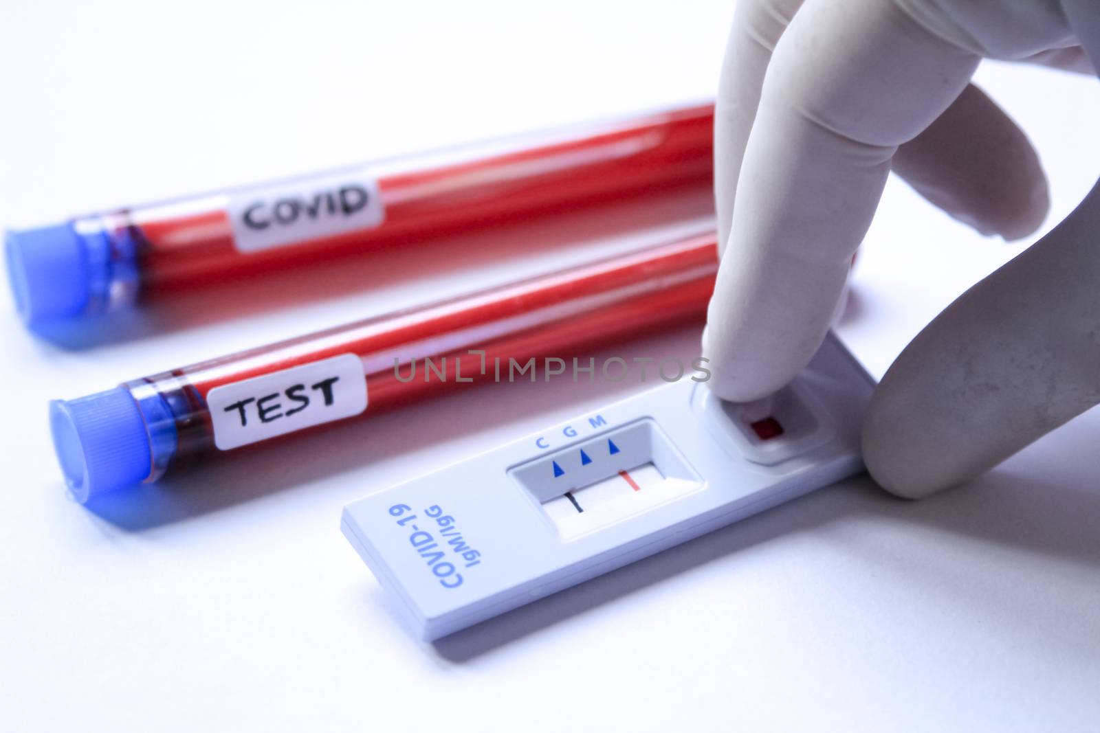 Medical worker placing blood sample on Rapid Diagnostic Test by soniabonet