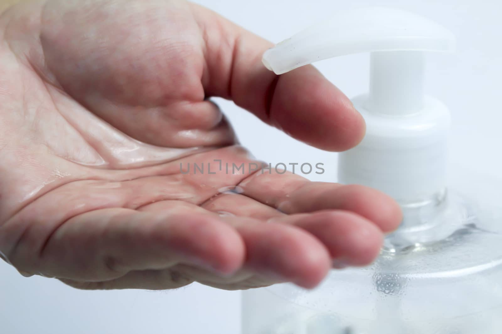 Hydroalcoholic gel bottle pouring gel into a hand by soniabonet
