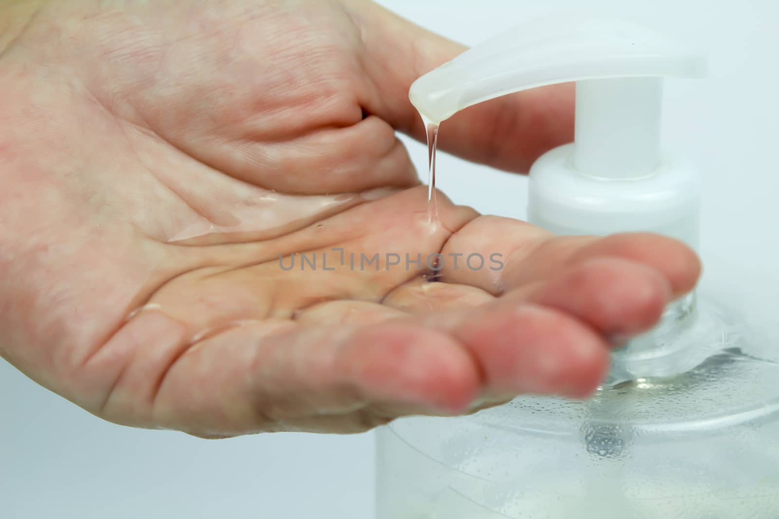 Hydroalcoholic gel bottle pouring gel into a hand by soniabonet