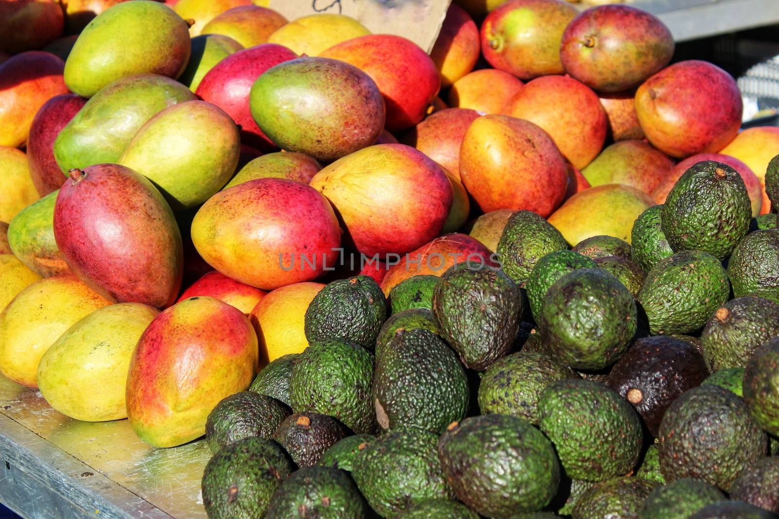 Mangoes and avocados at a market stall by soniabonet