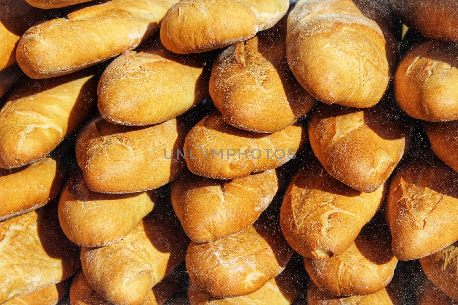 Stacked loaf of bread at a market stall by soniabonet