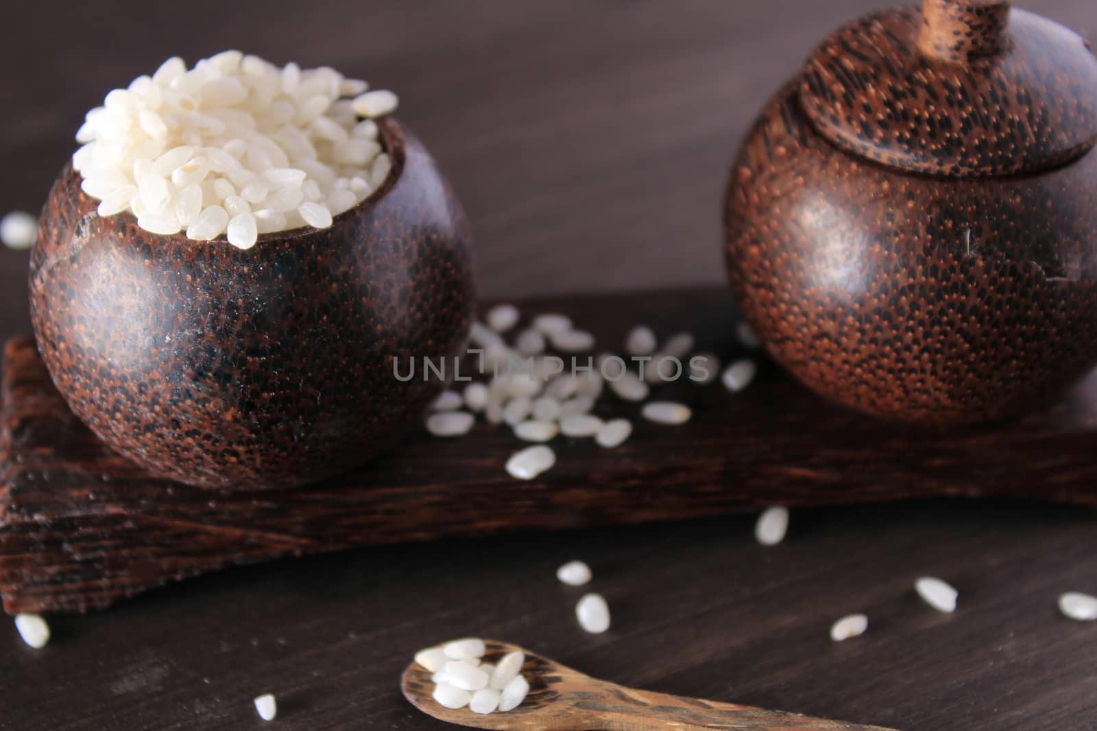 Small wooden bowls plenty with white rice. Little spoon on the table