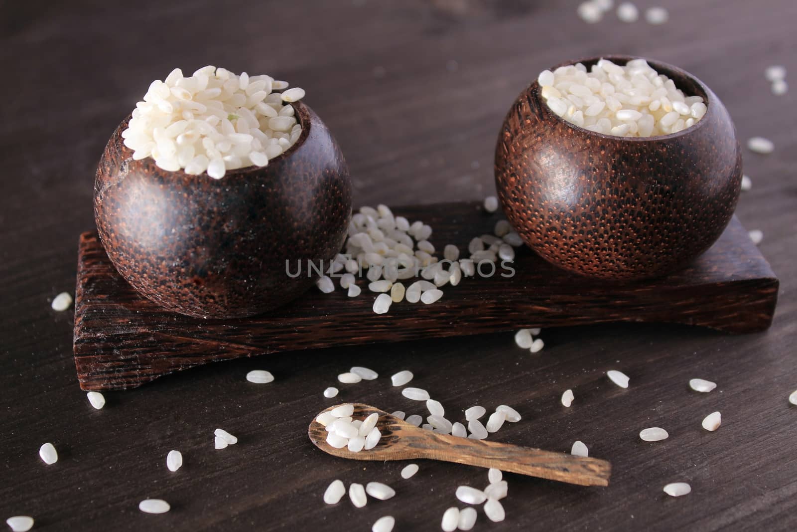 Small wooden bowls plenty with white rice. Little spoon on the table