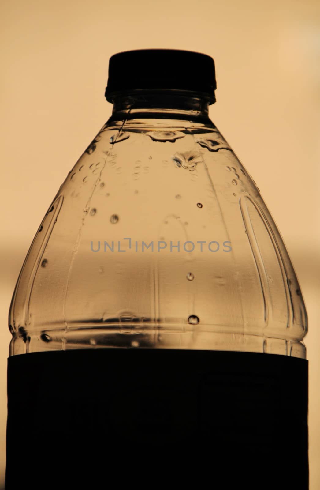 Silhouette of a plastic bottle of water. Dark picture.