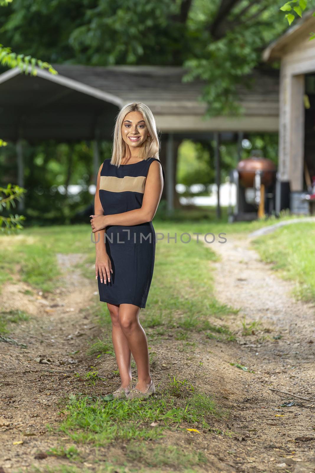 A gorgeous young blonde model poses outdoors while enjoying a summers day