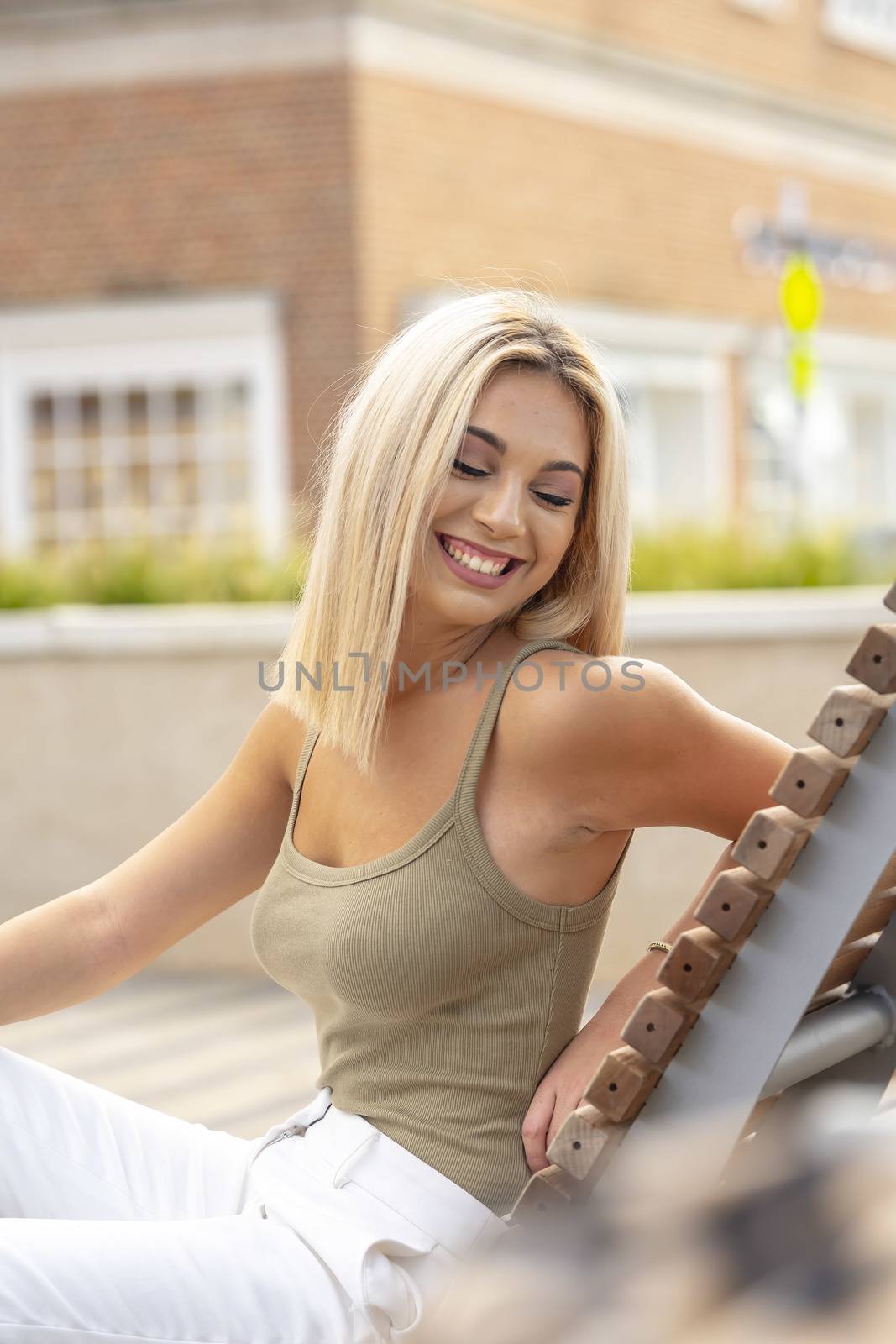 A gorgeous young blonde model poses outdoors while enjoying a summers day