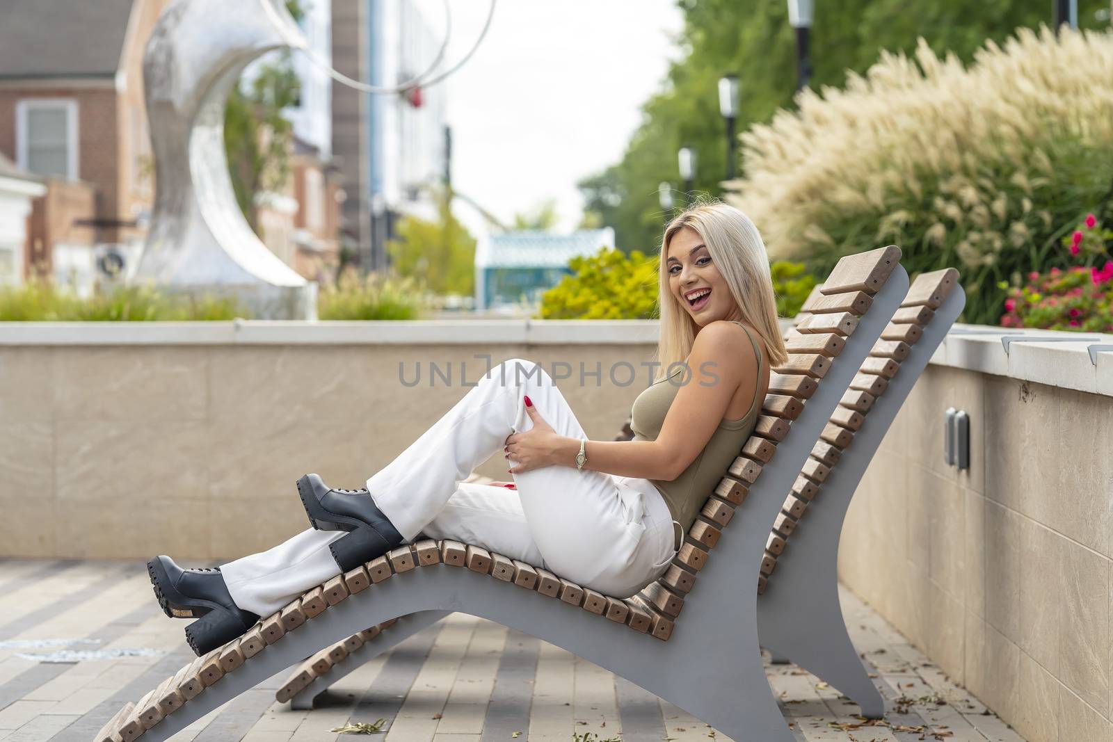 A gorgeous young blonde model poses outdoors while enjoying a summers day