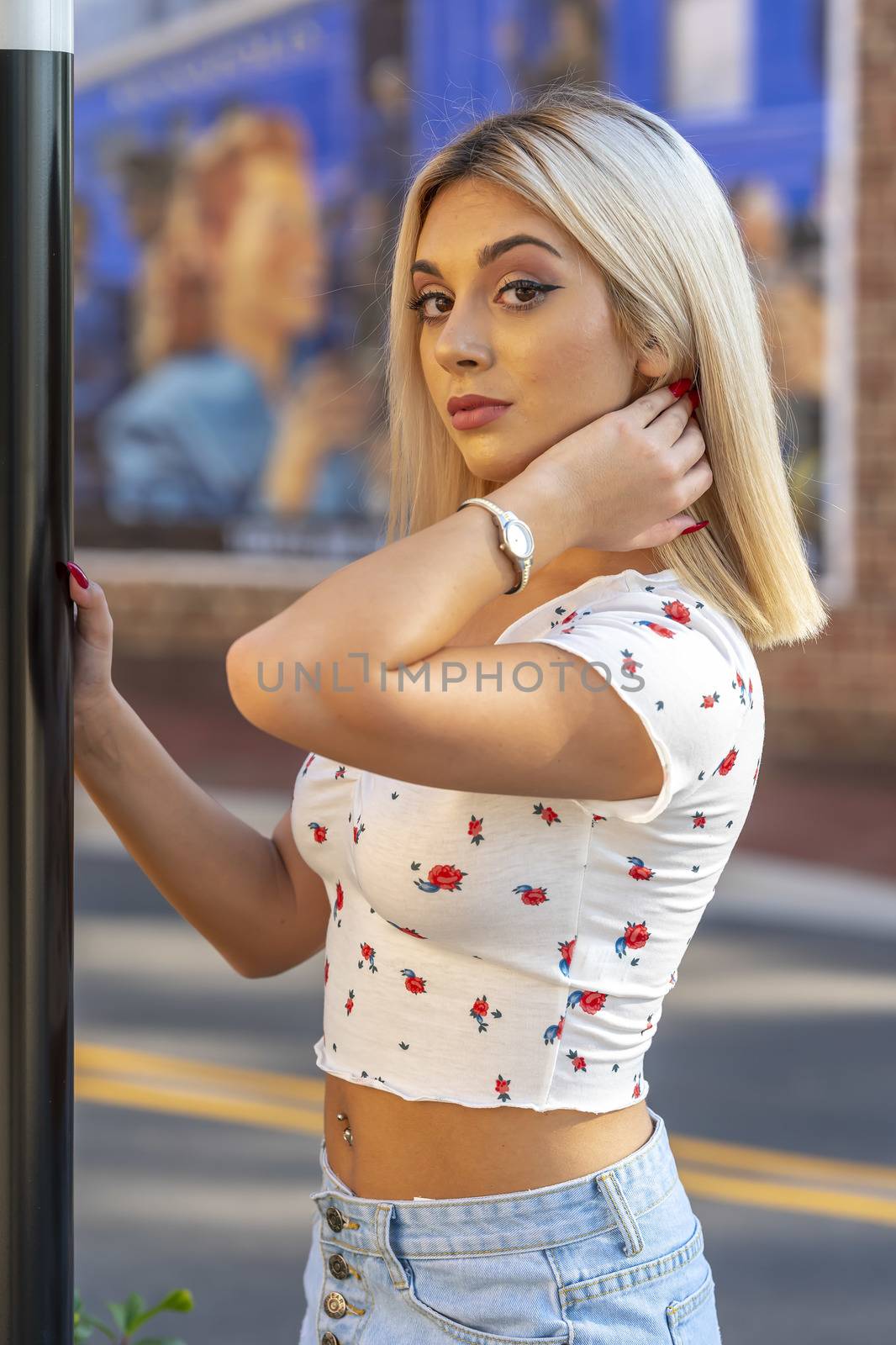 A gorgeous young blonde model poses outdoors while enjoying a summers day