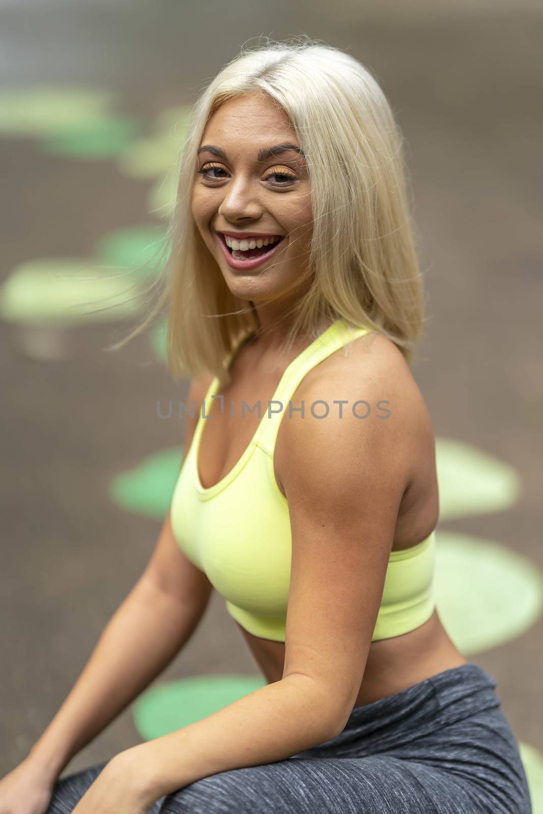 A gorgeous young blonde model works out outdoors while enjoying a summers day
