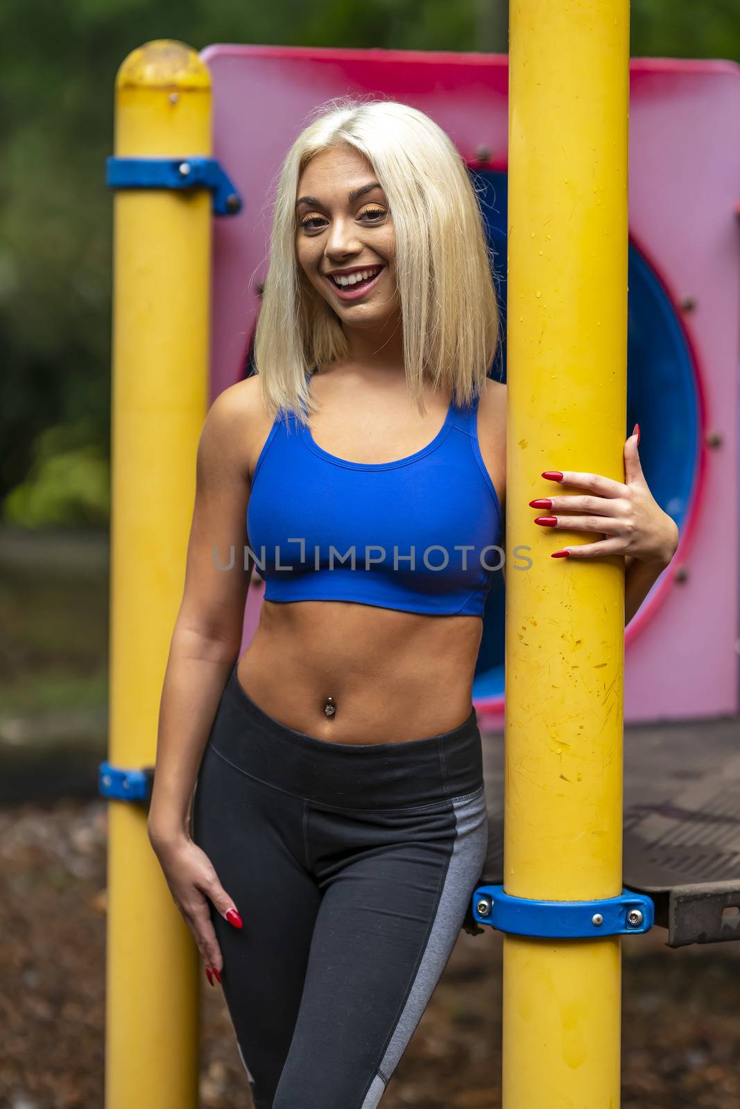 A gorgeous young blonde model works out outdoors while enjoying a summers day