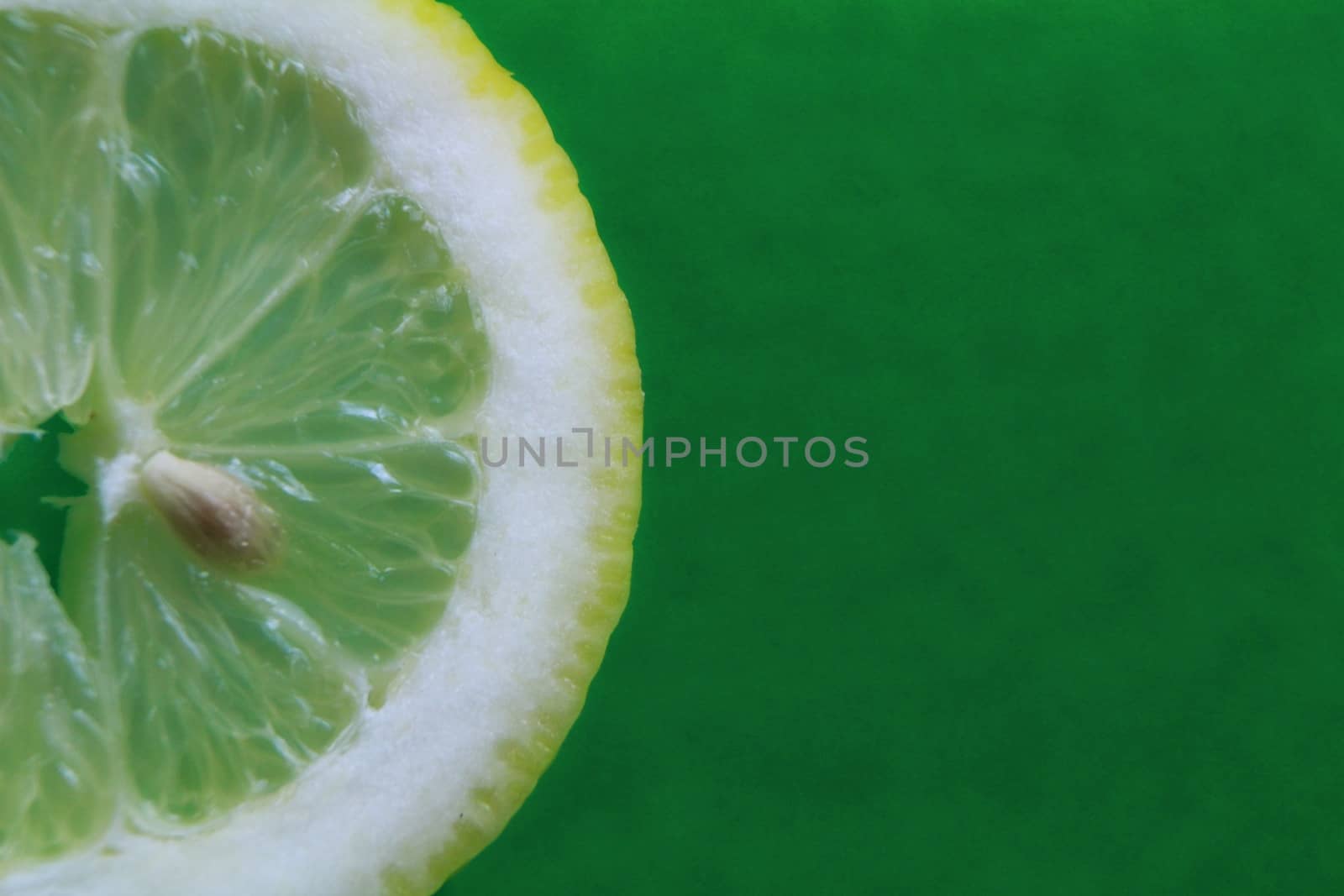 Slice of lemon on green background by soniabonet