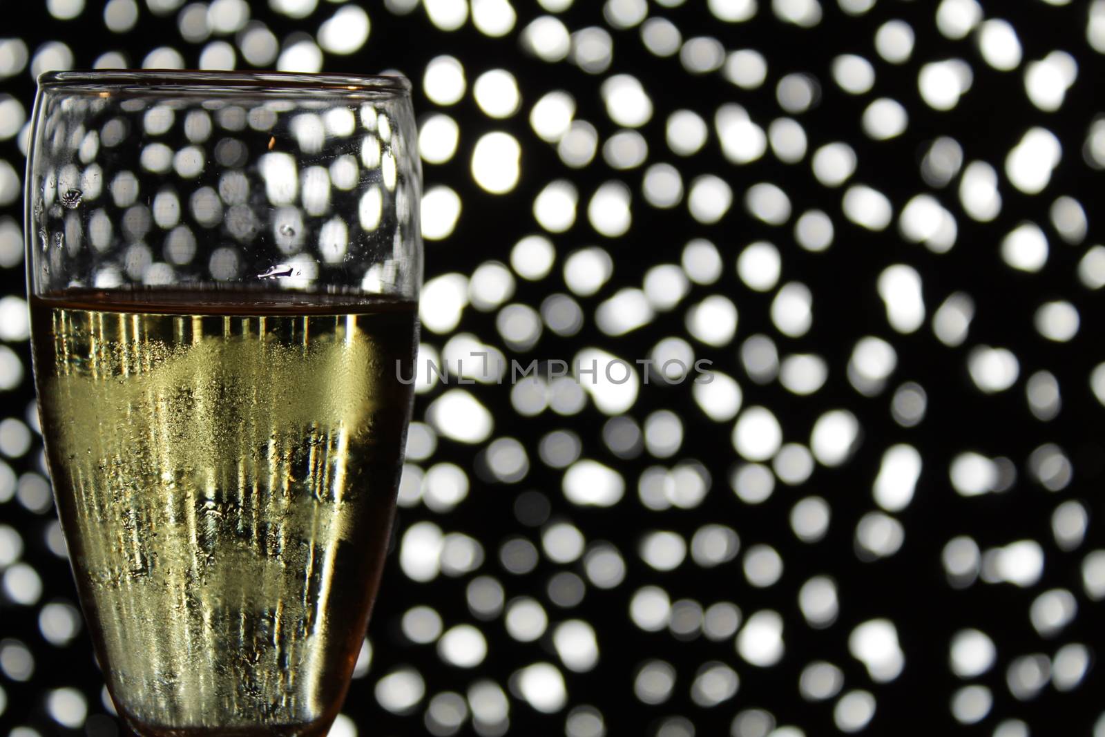 Champagne glasses toasting over Christmas light bokeh by soniabonet