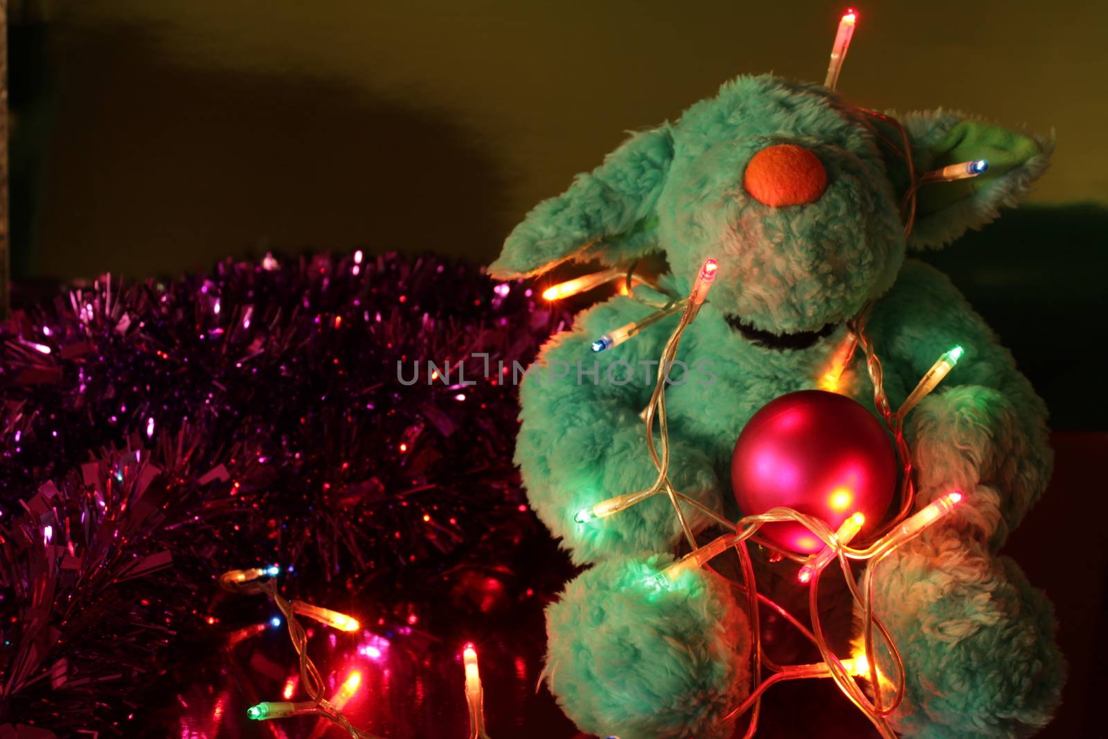 Teddy bear with Christmas tree balls, garlands and other colorful decorative elements