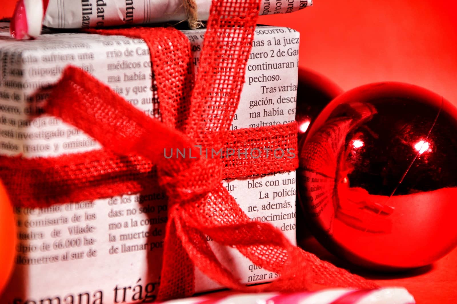 Gifts wrapped in old newspaper on red background by soniabonet