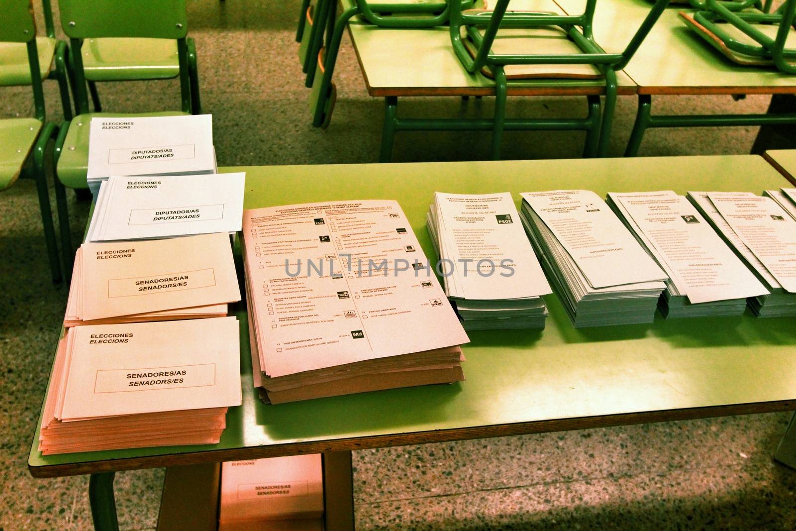 Ballots and envelops to vote on a wooden table at a polling station in Spain