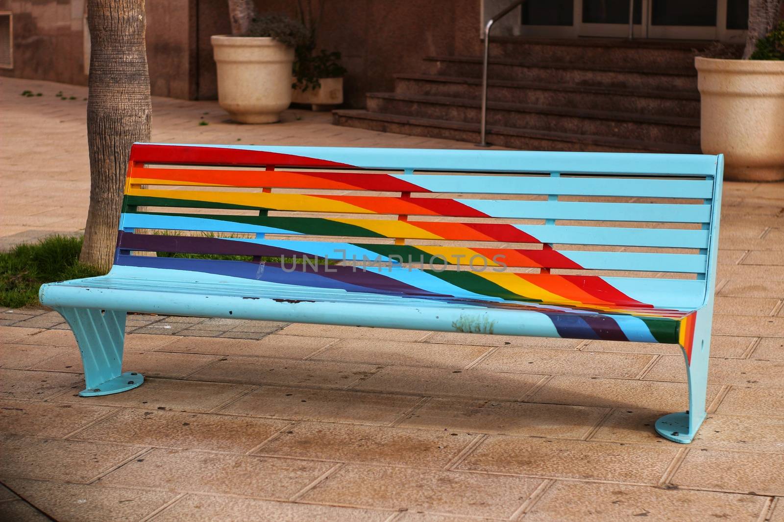 Bench in the city painted with the rainbow flag for gay pride celebration