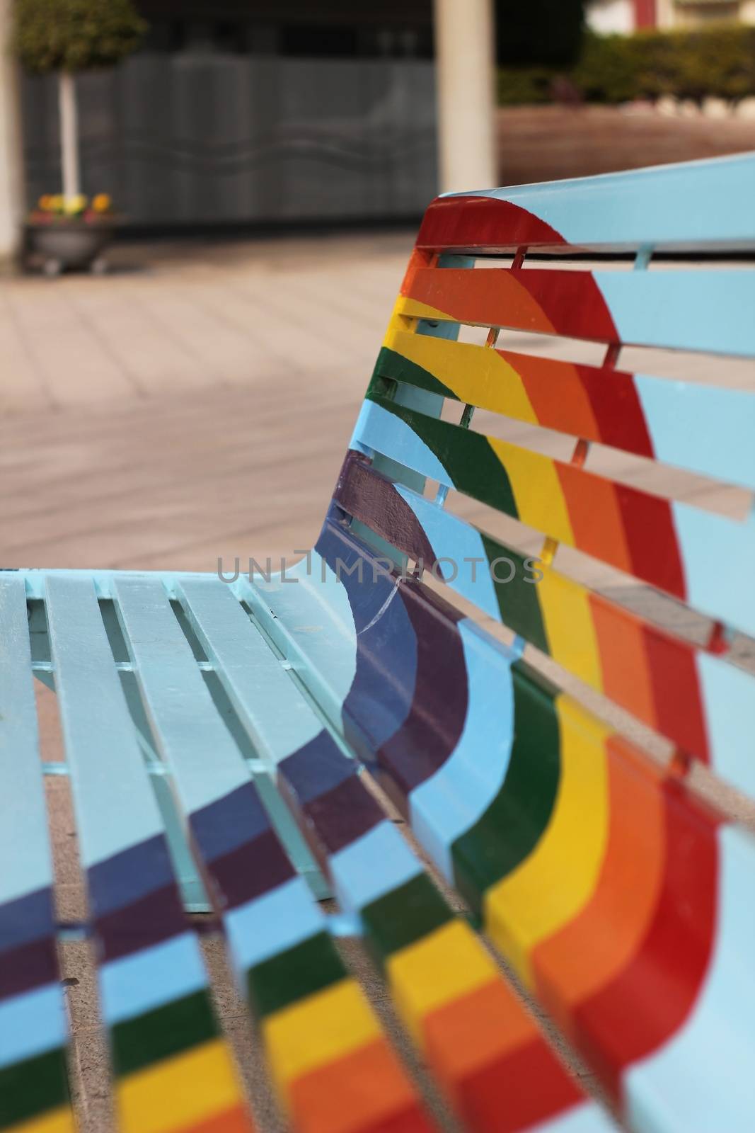 Bench in the city painted with the rainbow flag for gay pride celebration