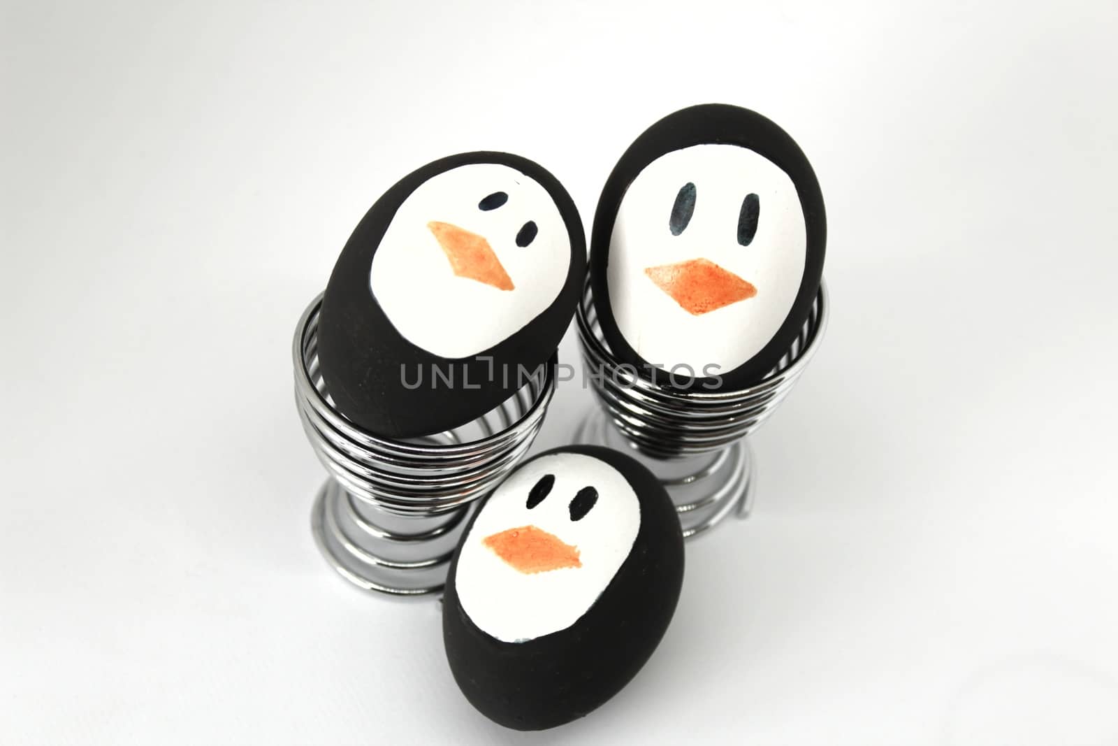 Penguin Easter Eggs on metal egg cup white background by soniabonet