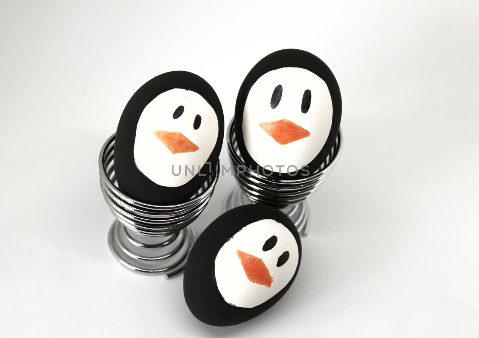 Penguin Easter Eggs made by hand on metal egg cup white background
