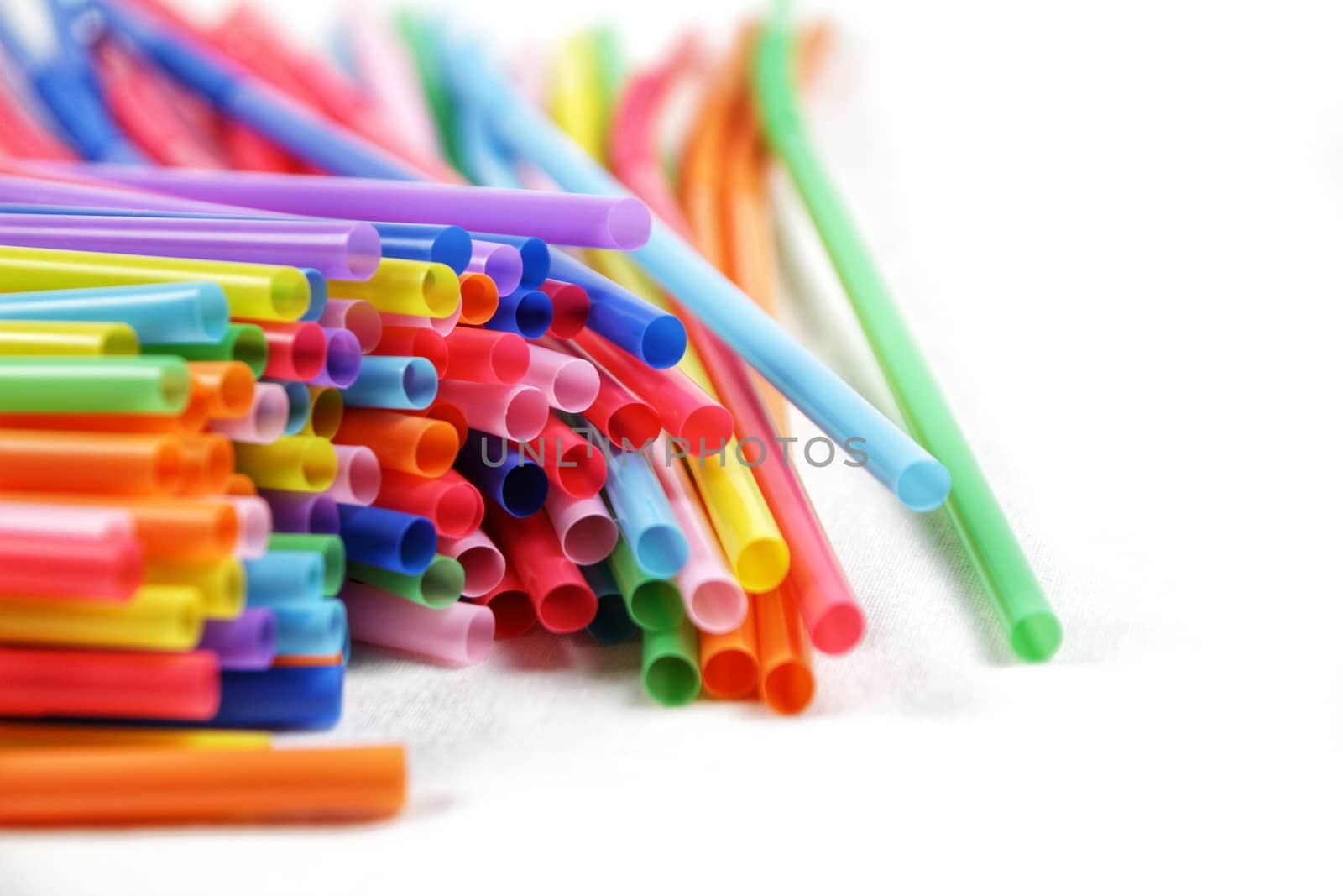 Colorful plastic drinking straws close up white background