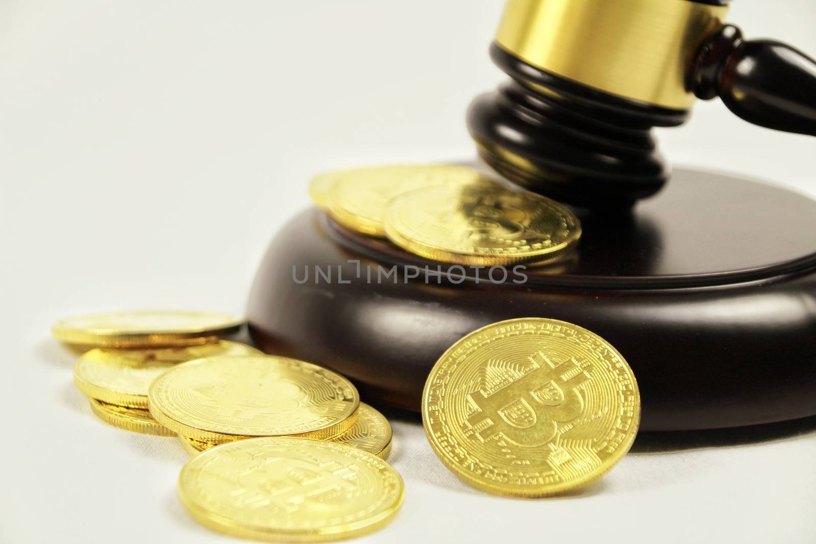 Golden bitcoins and judge gavel on white background