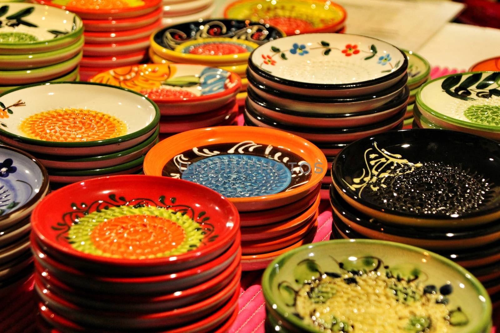 Beautiful and colorful ceramic plates for sale at a medieval market stall