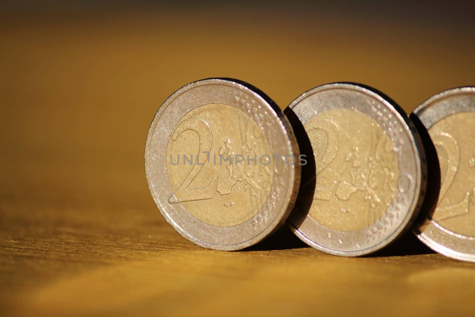 Two euro coins on brown wooden board