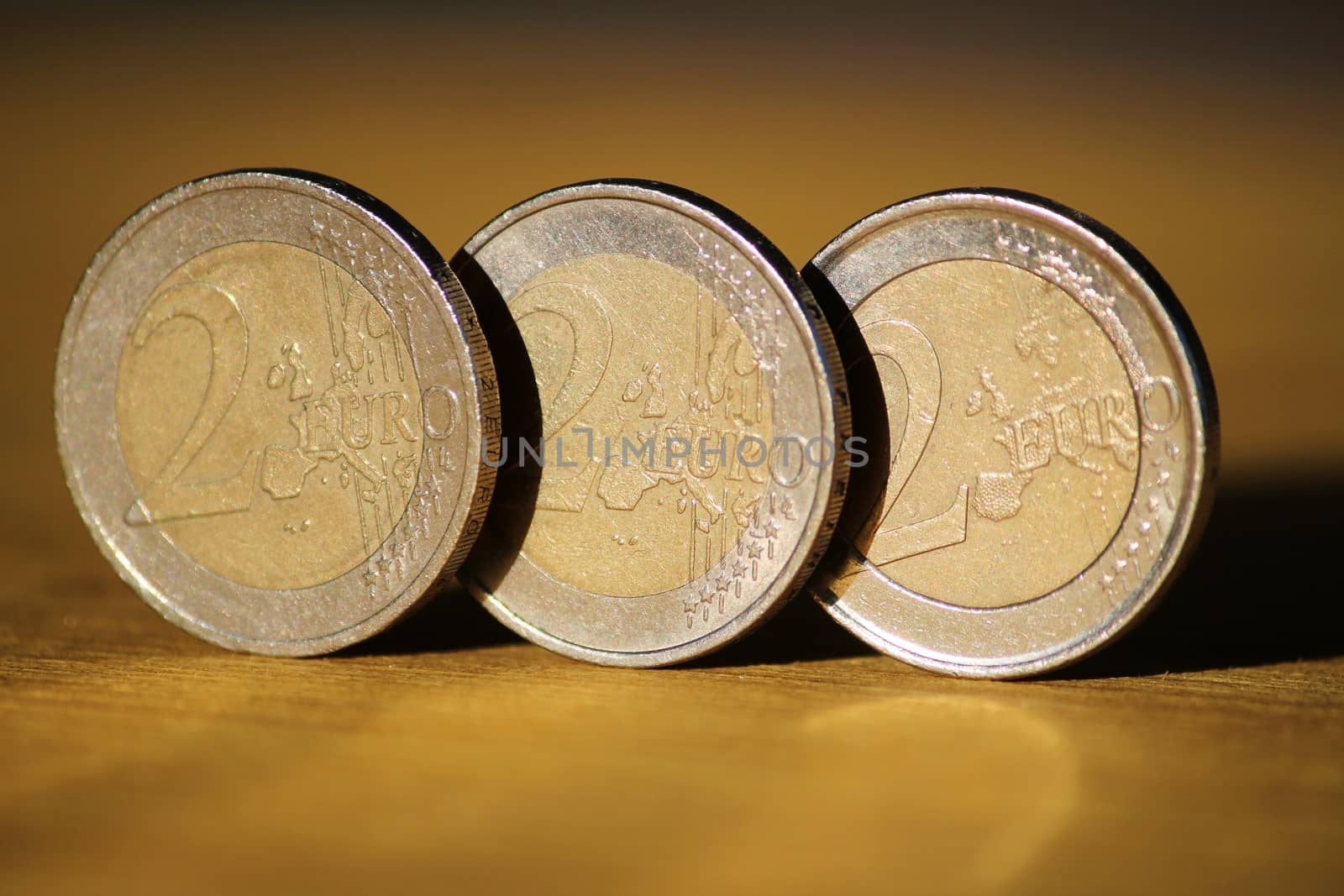 Two euro coins on wooden board by soniabonet
