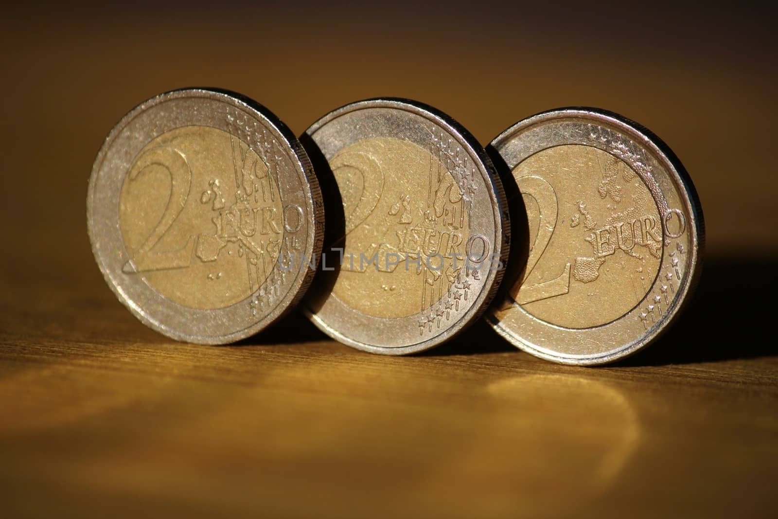 Two euro coins on brown wooden board