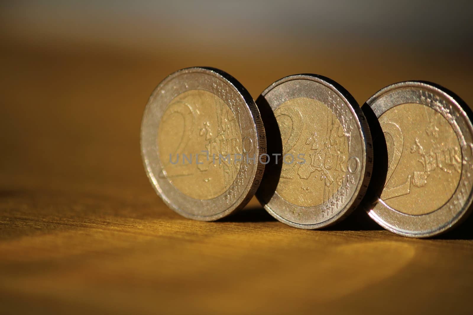 Two euro coins on brown wooden board