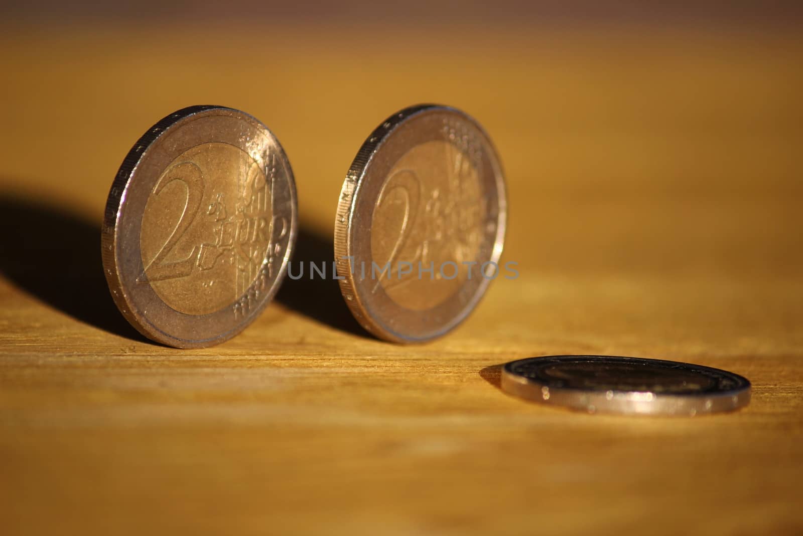 Two euro coins on brown wooden board