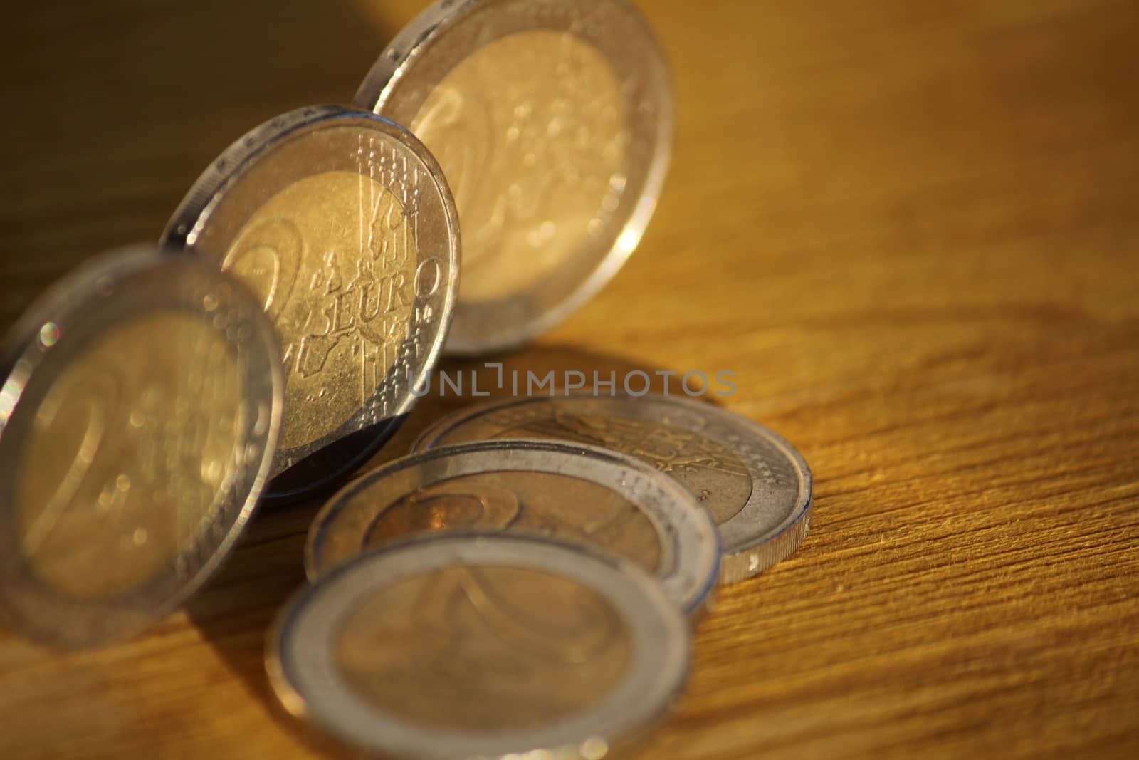 Two euro coins on brown wooden board