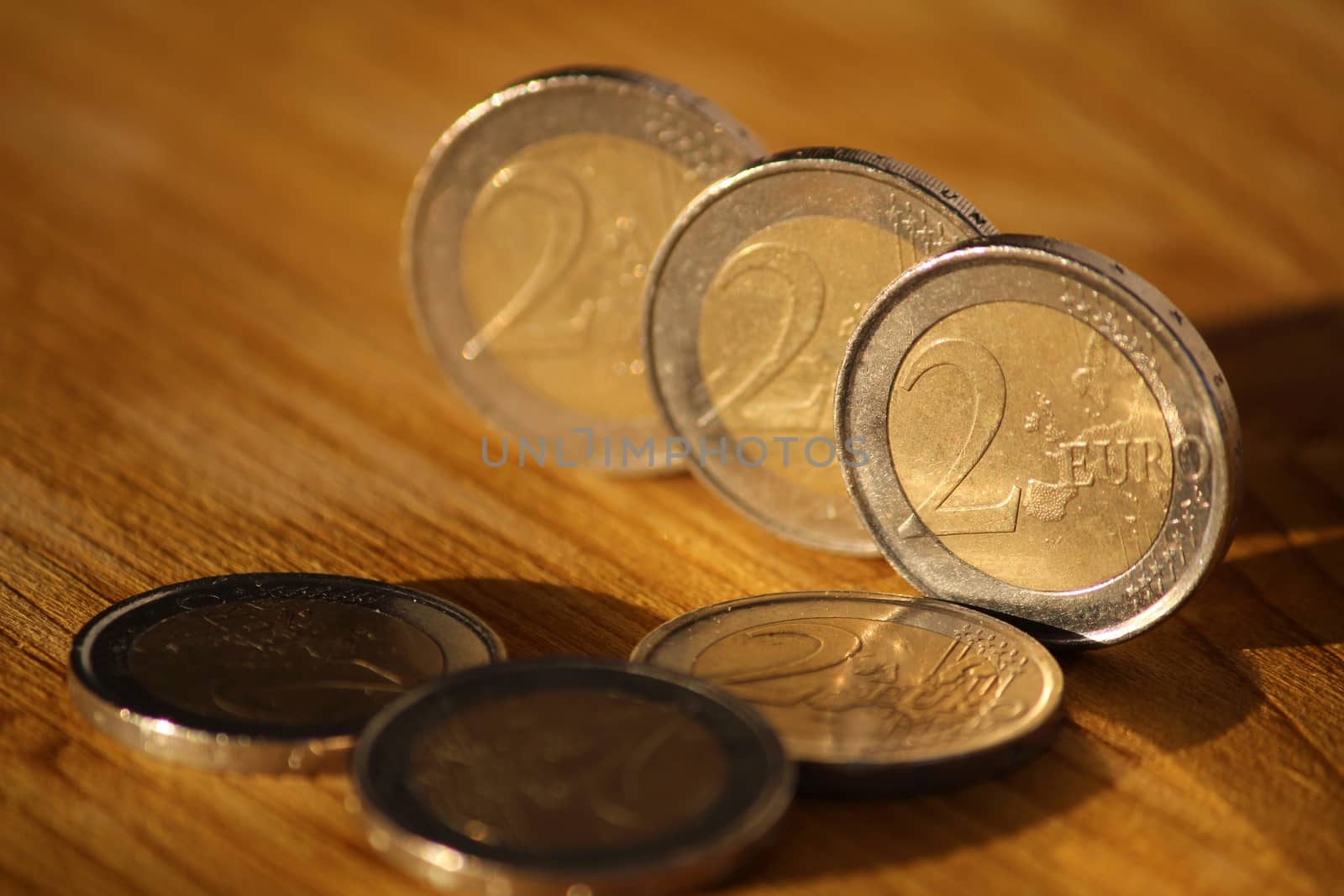 Two euro coins on brown wooden board