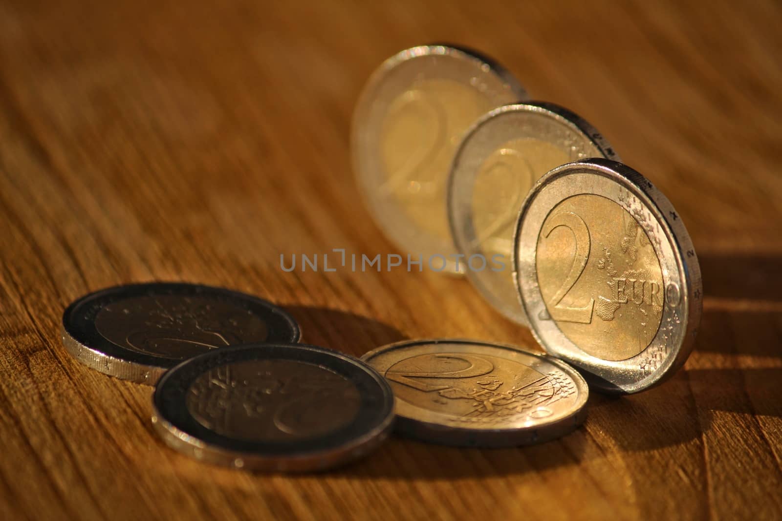 Two euro coins on brown wooden board