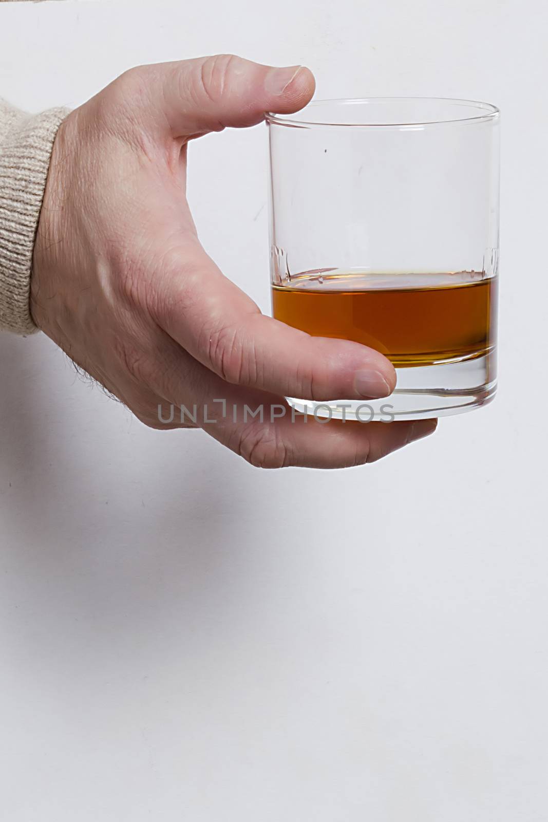 Hand with a glass of whiskey by VIPDesignUSA