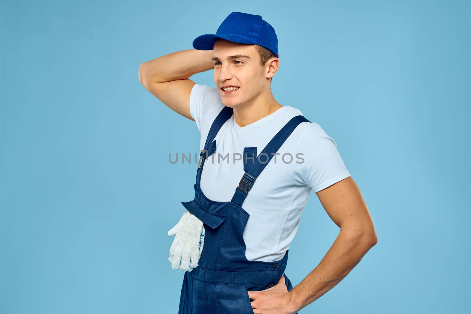Working man in uniform of gloves loader rendering service blue background. High quality photo