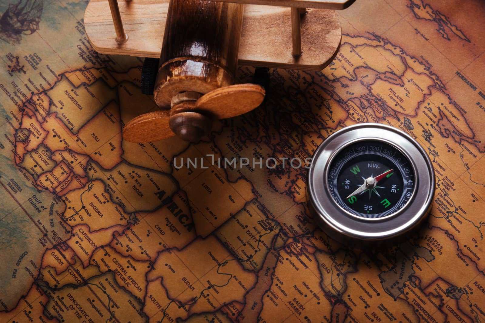 Old compass discovery and wooden plane on vintage paper antique  by Sorapop