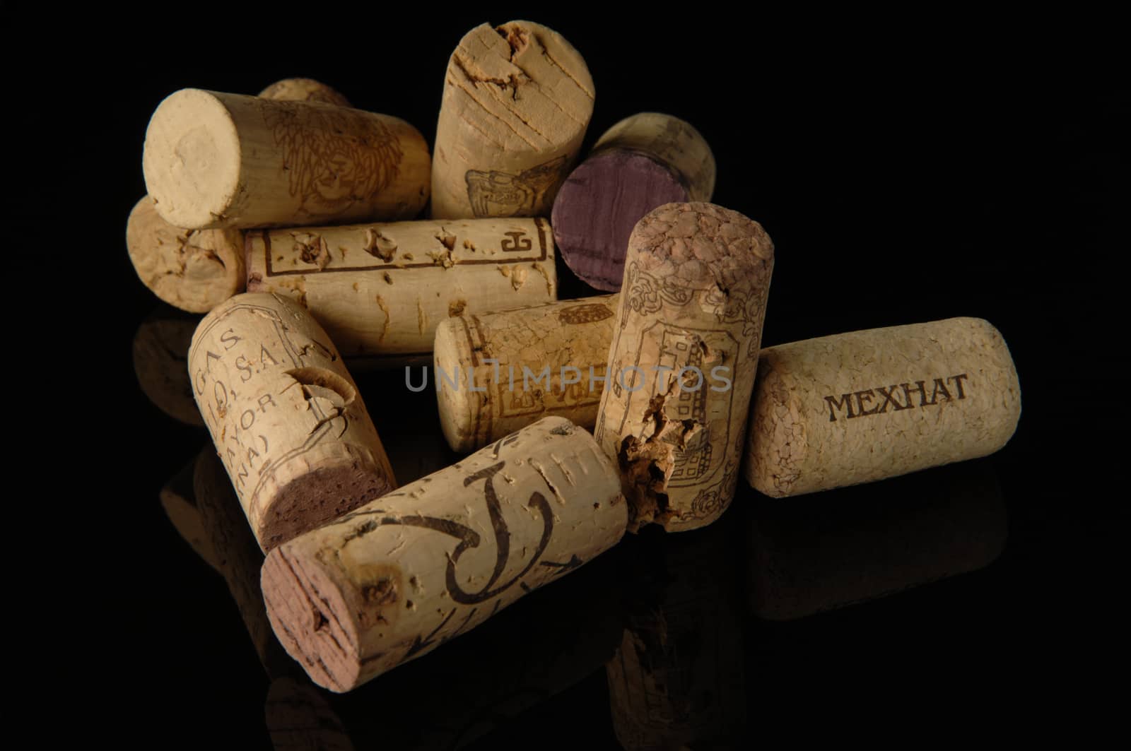Tashkent, Uzbekistan - October 6, 2009 : Heap of old wine corks on black background with reflection. Studio photography