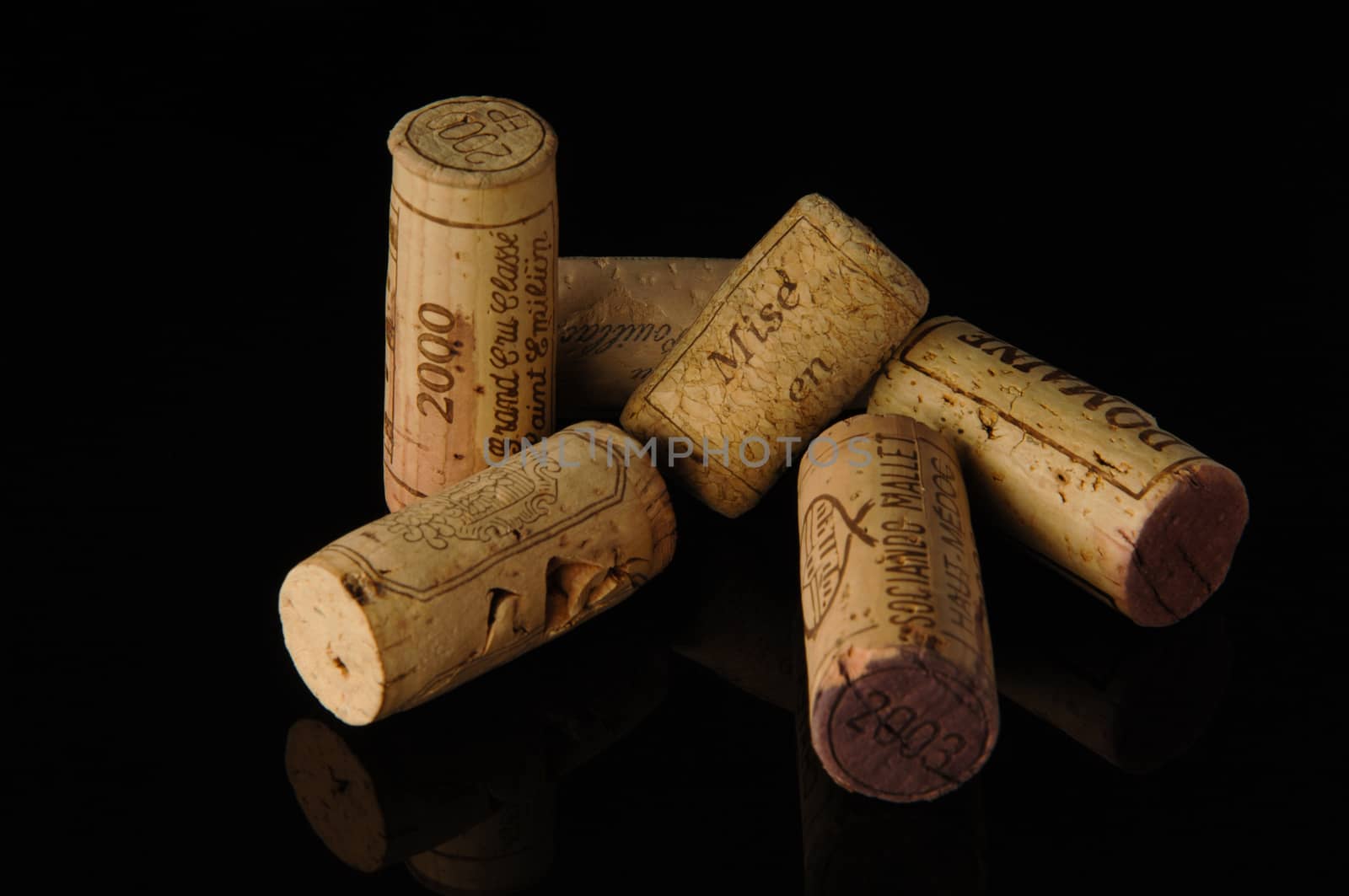 Tashkent, Uzbekistan - October 6, 2009 : Heap of old wine corks on black background with reflection. Studio photography
