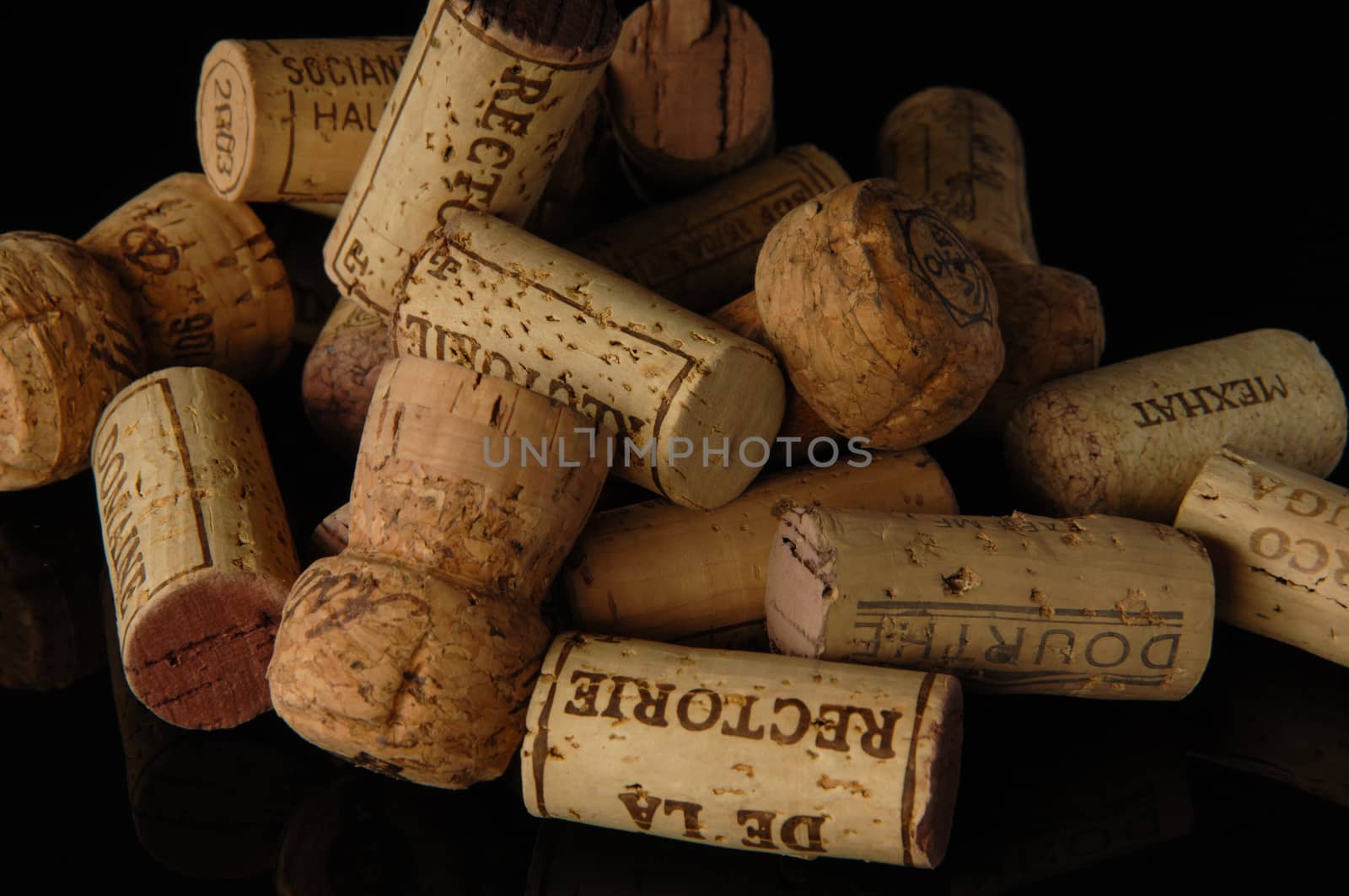 Tashkent, Uzbekistan - October 6, 2009 : Heap of old wine corks on black background with reflection. Studio photography
