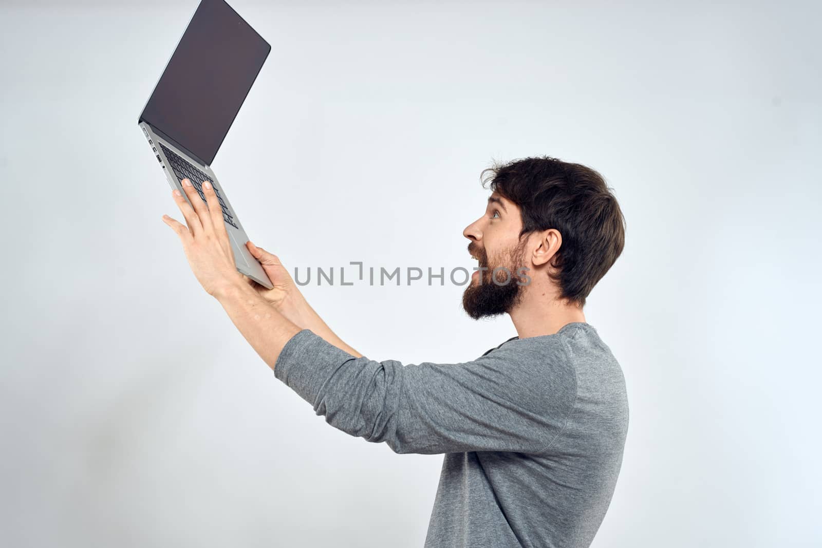 Bearded man with laptop in hands internet communication technology light background. High quality photo