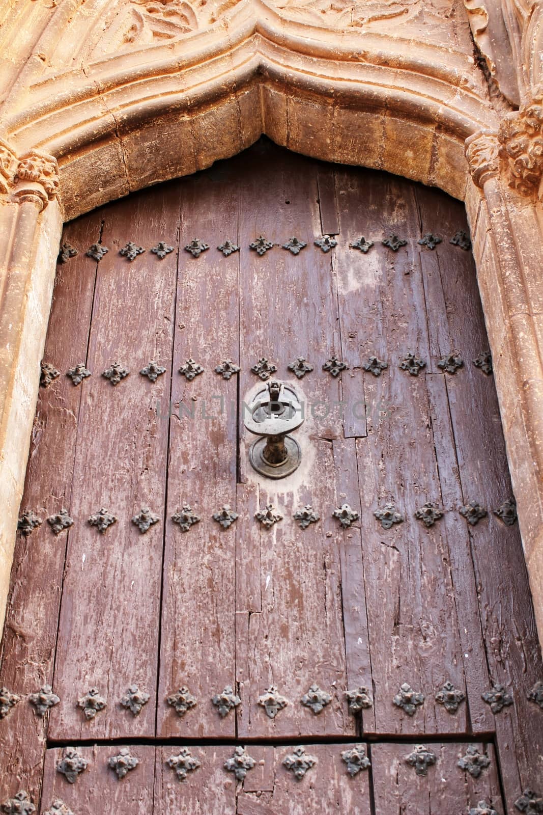 Old wooden door with wrought iron details in Villanueva de Los Infantes village, Spain