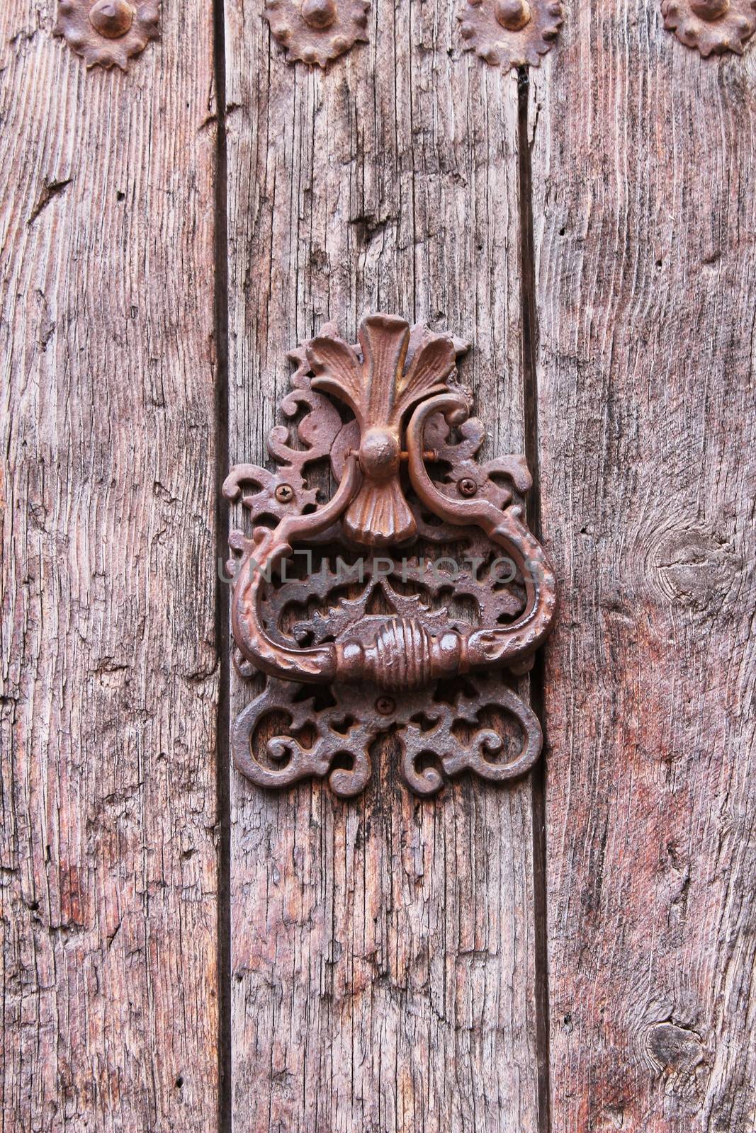 Vintage door knocker on old wooden door in Alcaraz, Spain