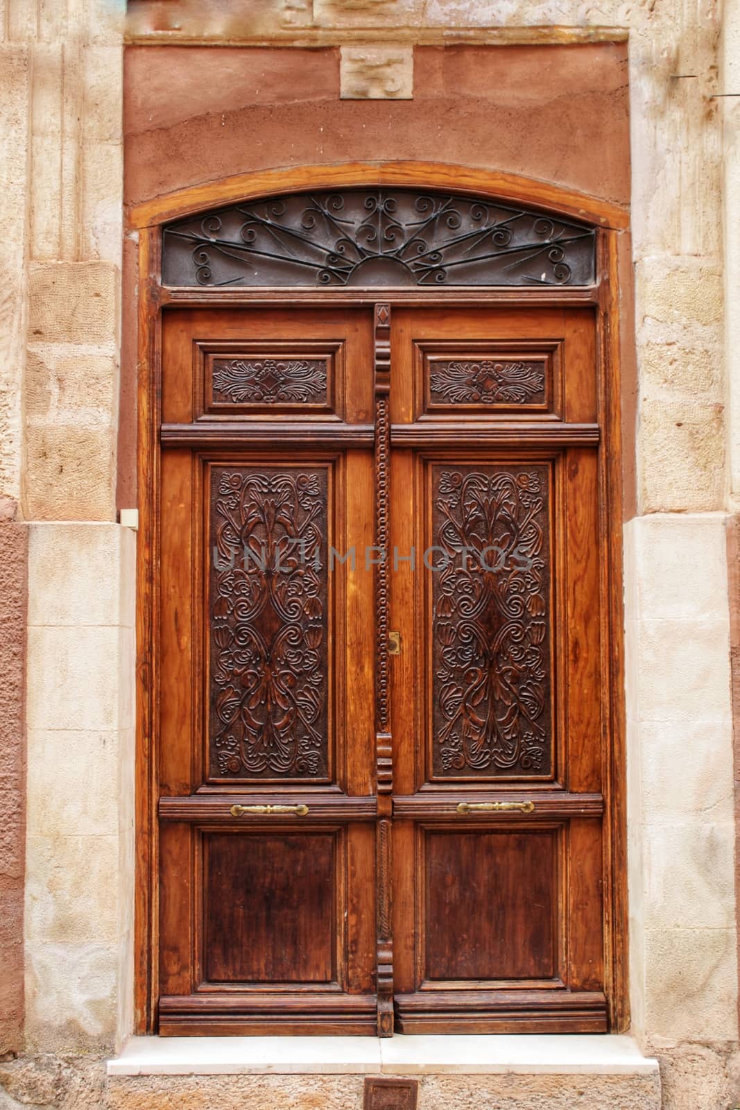 Old stone facade made of carved stone and vintage wooden door in a majestic house in Alcaraz, Albacete province, Spain.