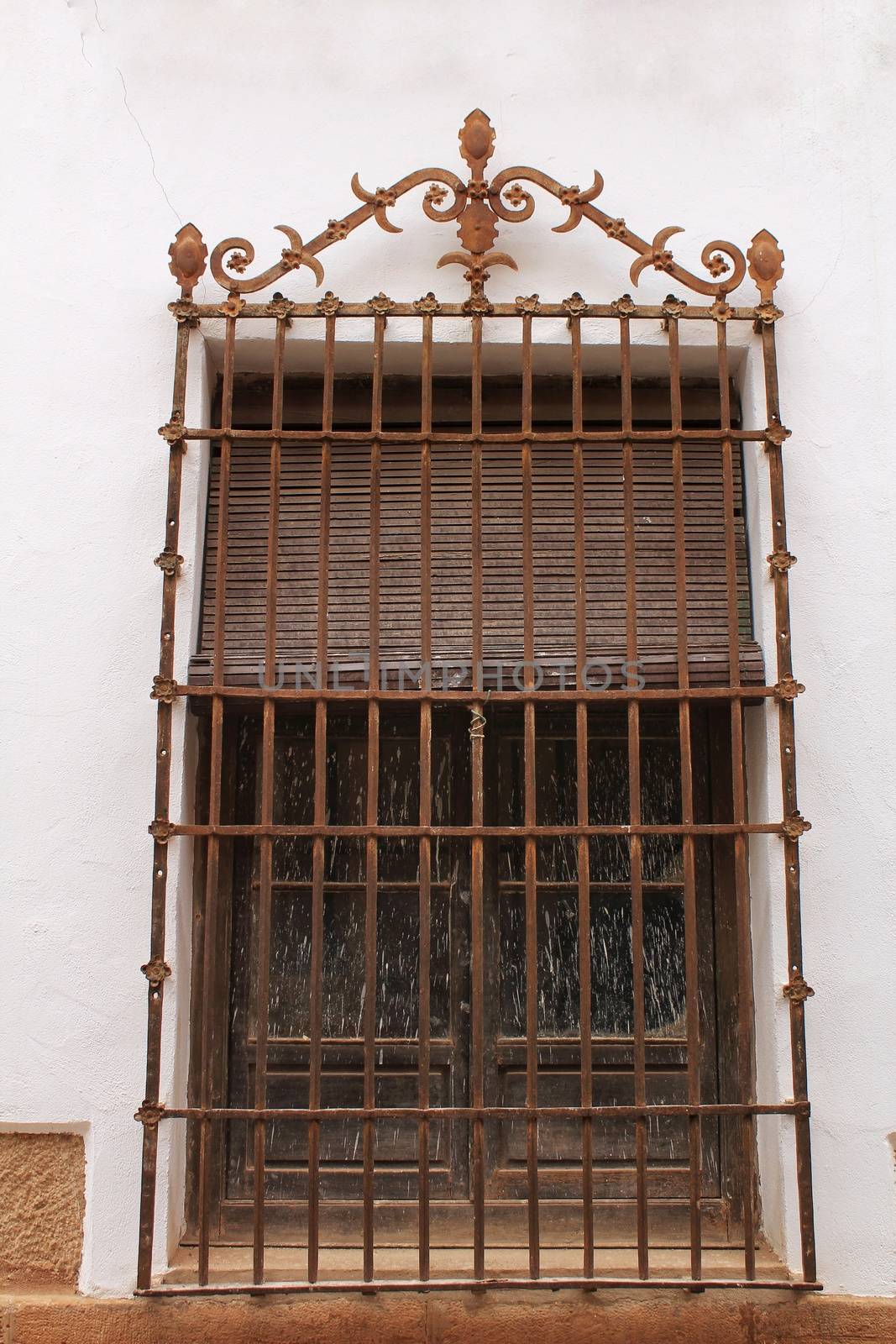 Old rusty wrought iron window on white facade in a house of Villanueva de los Infantes, Spain
