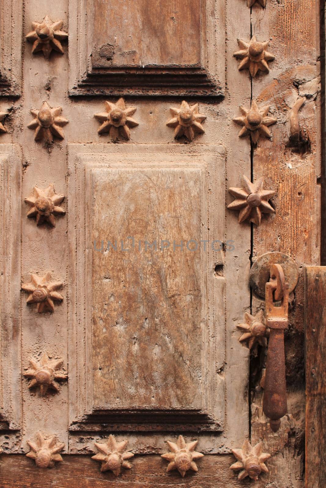 Old wooden door with wrought iron details with the shape of a star in Villanueva de Los Infantes village, Spain