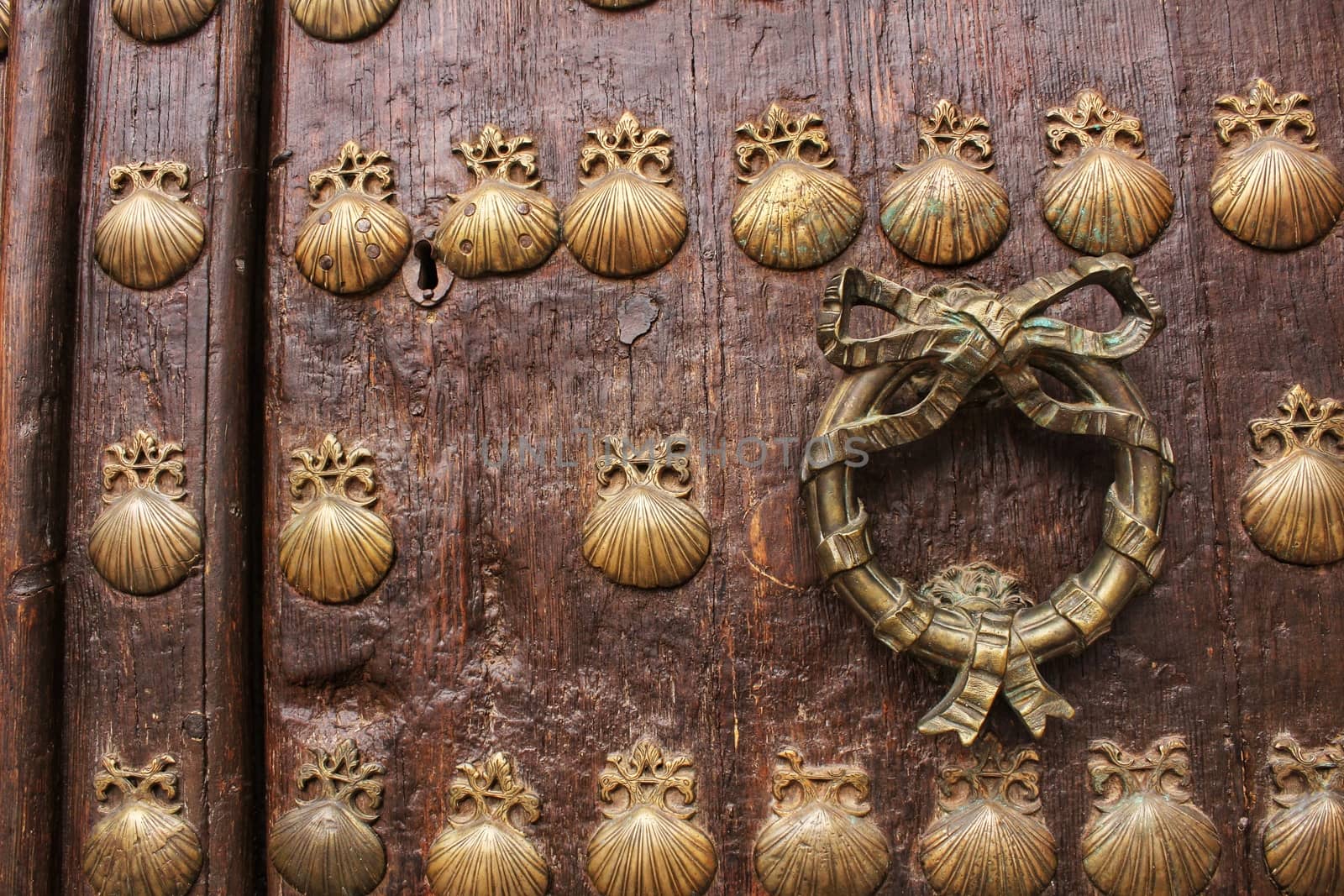 Old door with golden wrought iron details with figures of shells by soniabonet