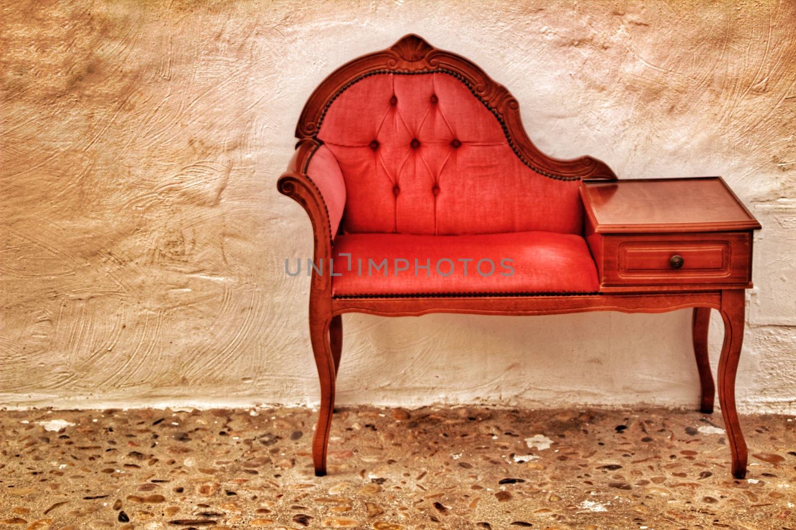 Beautiful and small antique vintage red divan in a cobblestone street in Altea, Spain