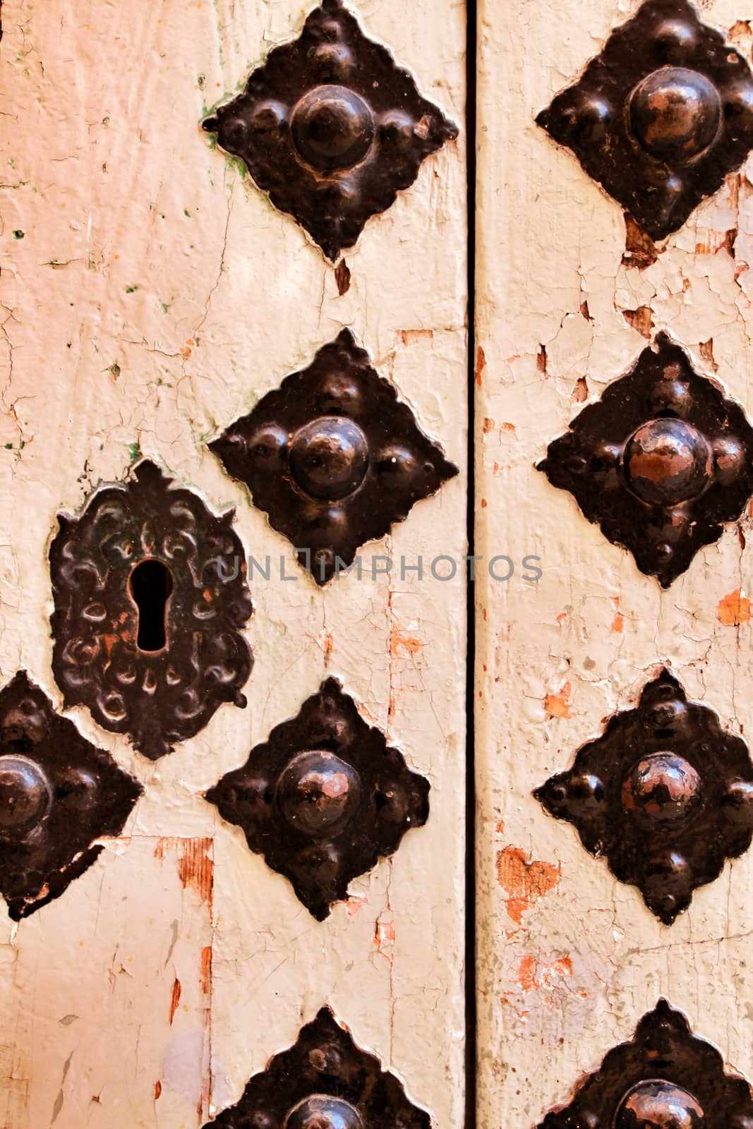 Old wooden door with wrought iron details in Xixona village, Alicante province, Spain.
