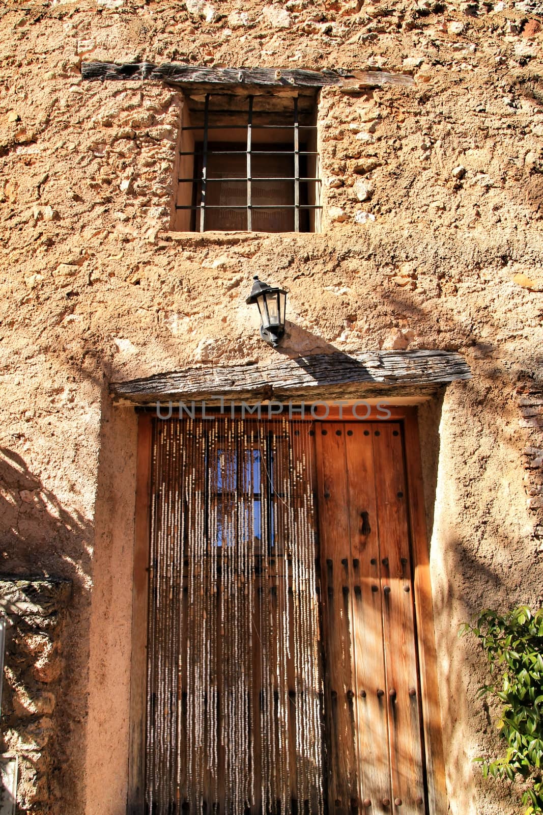 Old wooden door with wrought iron details on a stone facade in Riopar, Albacete, Spain.